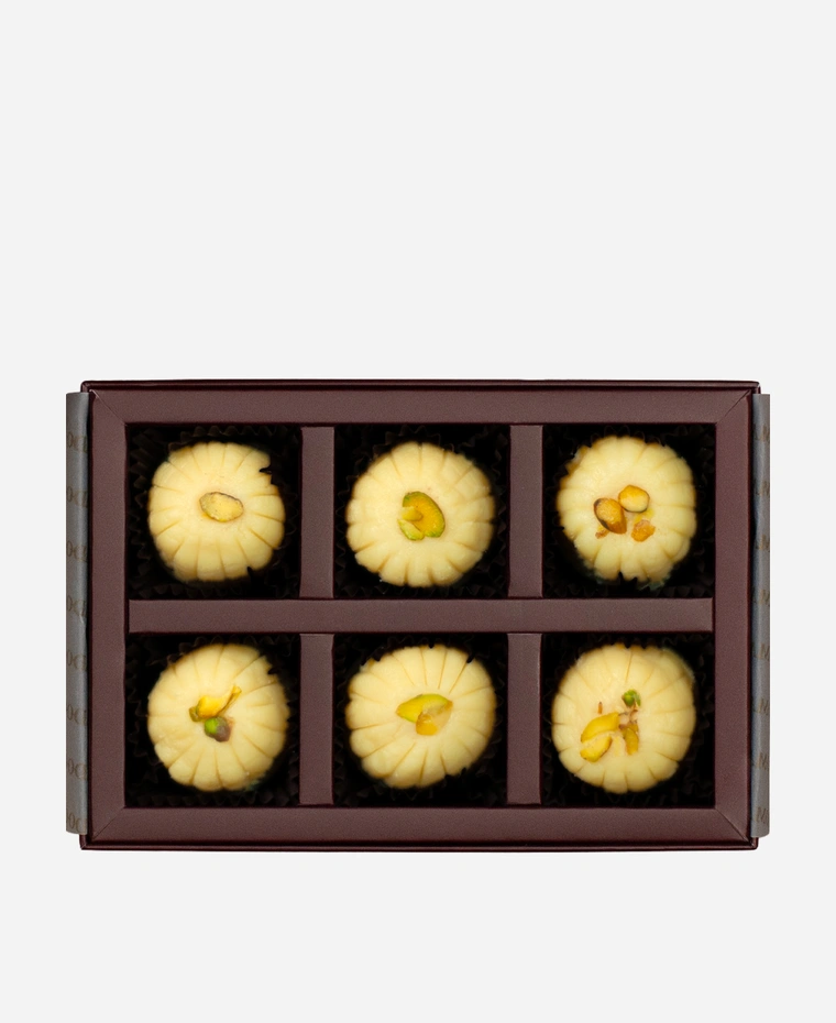 Khoya Peda gift box, 6 pieces, open: ivory khoya peda finished with pistachio in a burgundy box with gold foil lettering.