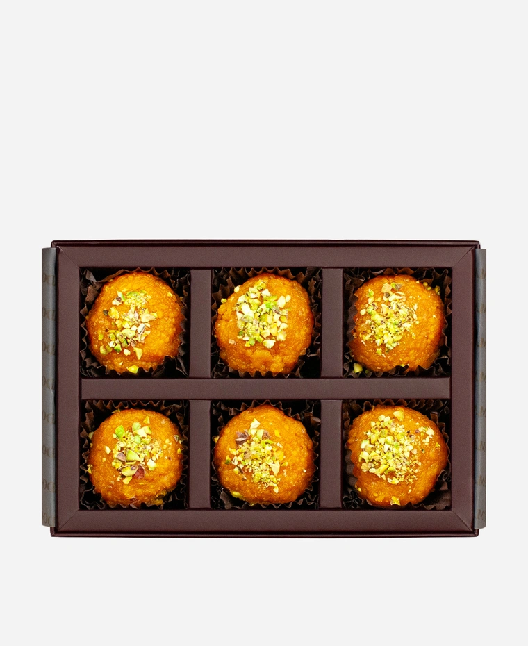 Pistachio Motichoor Ladoo gift box, 6 pieces, open: fine-grained motichoor ladoo topped with chopped pistachio in a burgundy box with gold foil lettering.
