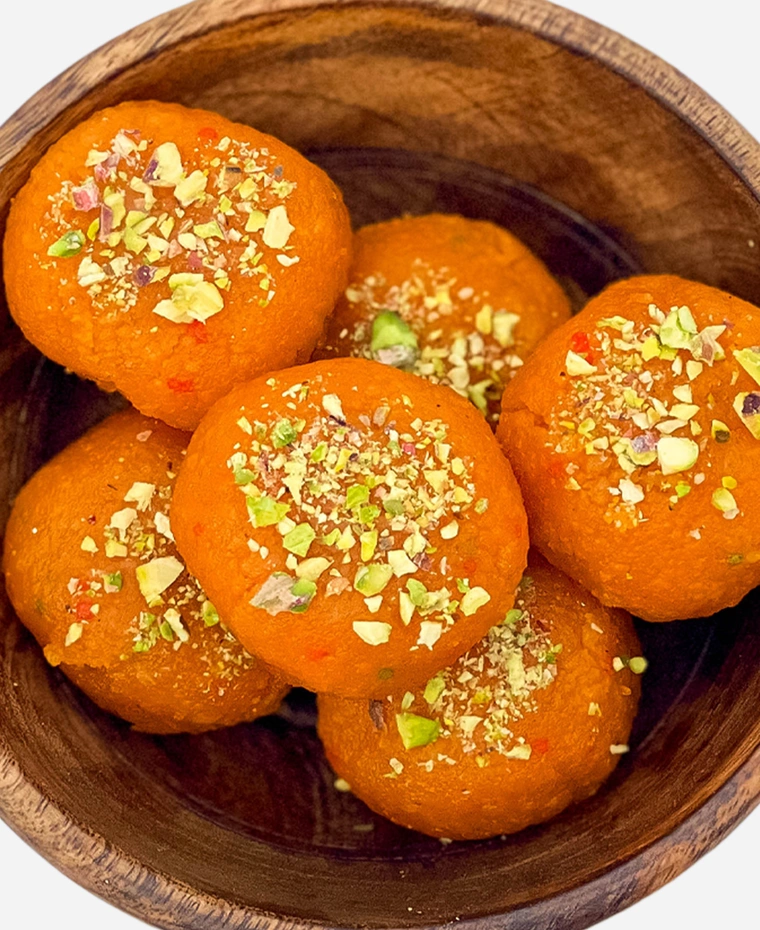 Close-up of handmade fine-grained motichoor ladoo topped with chopped pistachio.