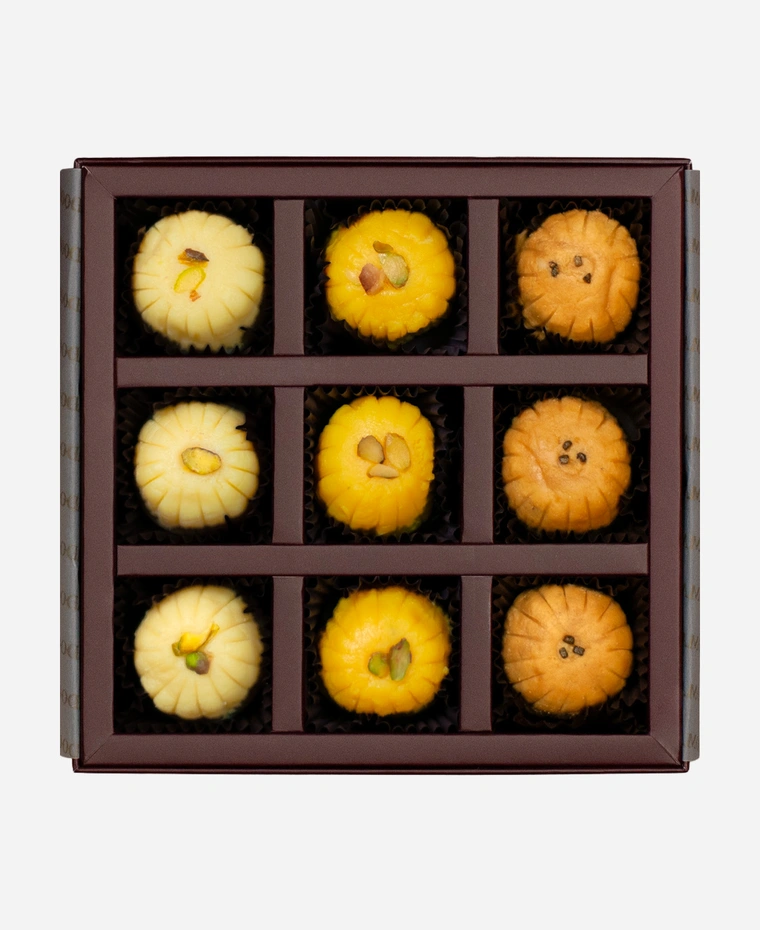 Signature Peda Selection gift box, 9 pieces, open: khoya, kesar and Mathura peda in a burgundy box with gold foil lettering.