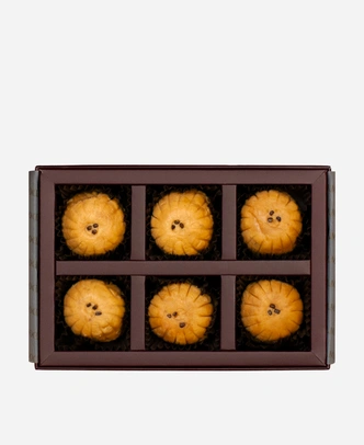 Mathura Peda gift box, 6 pieces, open: caramel-brown Mathura peda in a burgundy box with gold foil lettering.