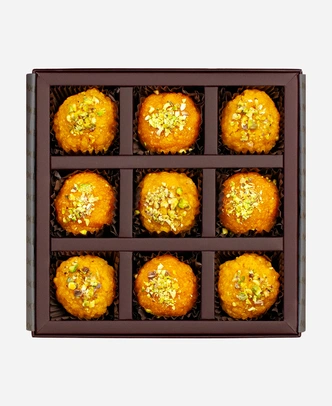 Pistachio Ladoo Selection gift box, 9 pieces, open: boondi and motichoor ladoo topped with chopped pistachio in a burgundy box with gold foil lettering.