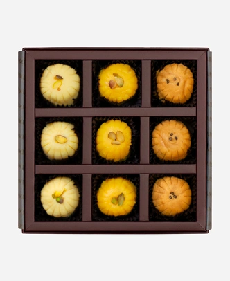 Signature Peda Selection gift box, 9 pieces, open: khoya, kesar and Mathura peda in a burgundy box with gold foil lettering.