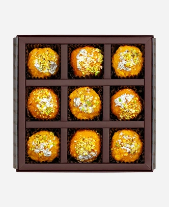 Silver Leaf & Pistachio Ladoo Selection gift box, 9 pieces, open: boondi and motichoor ladoo topped with edible silver leaf and chopped pistachio in a burgundy box with gold foil lettering.