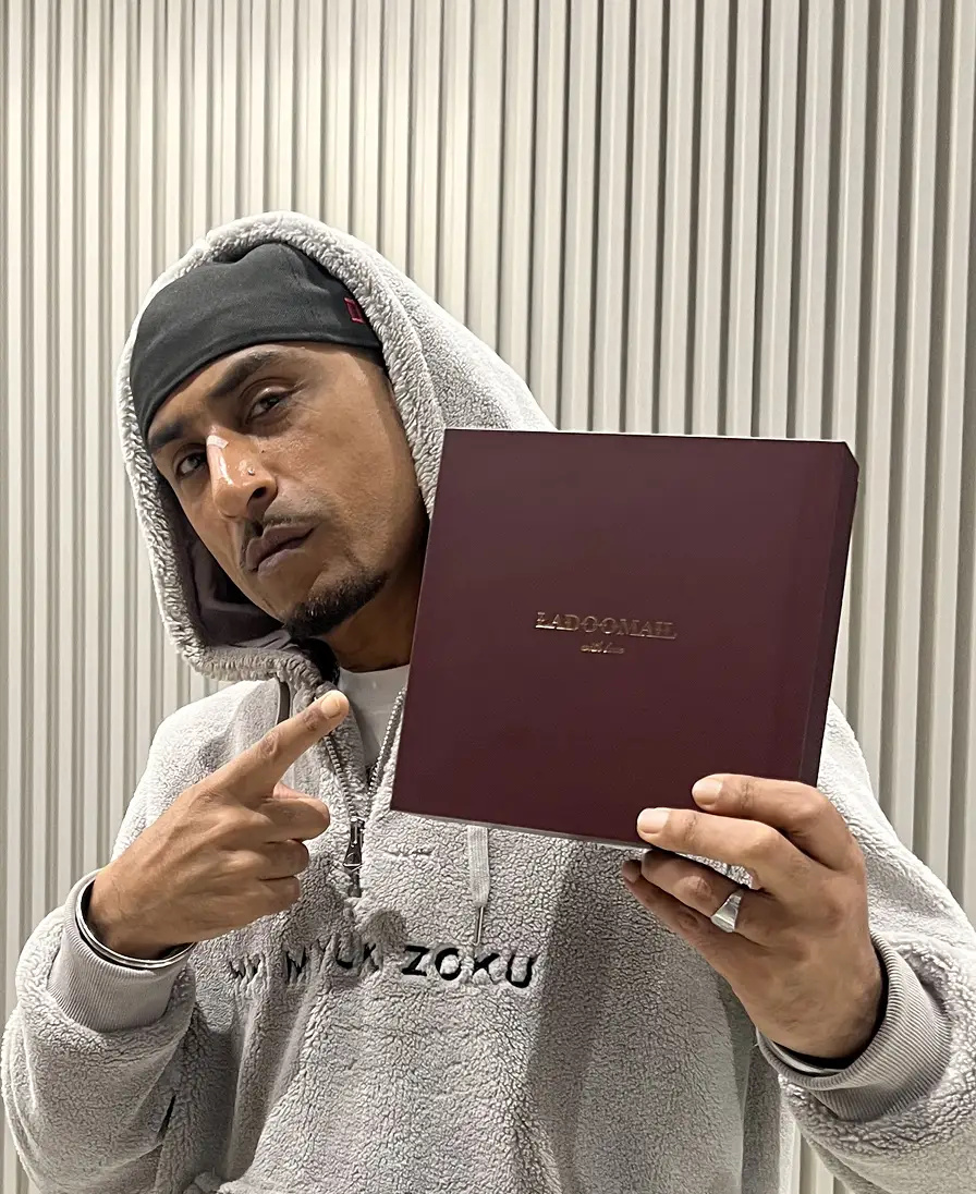 Man in a grey hoodie holding an open burgundy Ladoomail keepsake box.