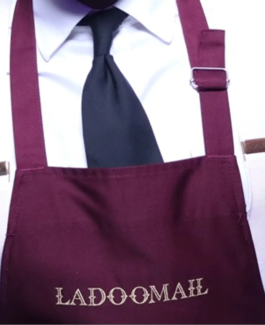 Burgundy Ladoomail-branded apron worn by a display attendant.